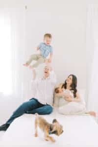 parents with toddler and newborn throwing toddler up newborn photos roswell